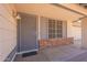 Covered front porch featuring a gray security screen door, red brick accents, and decorative window with a grid pattern at 1165 E Ivanhoe St, Chandler, AZ 85225