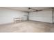 Spacious garage with a white door, concrete floor, storage shelf, and cabinets providing ample space at 1165 E Ivanhoe St, Chandler, AZ 85225
