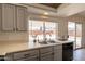 Well-lit kitchen with stainless steel sink, neutral countertops, and gray cabinetry at 1165 E Ivanhoe St, Chandler, AZ 85225