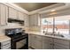 Modern kitchen with gray cabinets, stainless steel appliances, and natural light at 1165 E Ivanhoe St, Chandler, AZ 85225