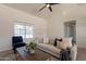 Cozy living room featuring a comfortable sofa, decorative throw pillows, a ceiling fan, and a neutral color palette at 1165 E Ivanhoe St, Chandler, AZ 85225