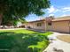 Serene backyard with a lush green lawn, mature trees, sidewalk, covered patio, and satellite dishes at 1306 W 12Th St, Tempe, AZ 85281