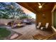 Covered patio leads to an outdoor area with fire pit, seating, hot tub, and greenery, perfect for entertaining at 13145 W Whisper Rock Trl, Peoria, AZ 85383