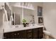 Well-lit bathroom features a double sink vanity, large mirror, tiled floors, and modern fixtures at 13145 W Whisper Rock Trl, Peoria, AZ 85383