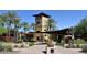 A modern community center with a tower, palm trees, and shaded areas for residents to enjoy at 13145 W Whisper Rock Trl, Peoria, AZ 85383