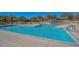 Large, inviting community pool with lounge chairs, umbrellas, and lush landscaping for relaxation and enjoyment at 13145 W Whisper Rock Trl, Peoria, AZ 85383