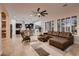 Bright open-concept living area featuring tile floors, a comfortable sectional sofa, and modern kitchen at 13145 W Whisper Rock Trl, Peoria, AZ 85383