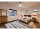 Cozy bedroom features a comfortable bed, wood floors, neutral décor, and lots of natural light at 13145 W Whisper Rock Trl, Peoria, AZ 85383