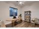 Bright and airy office space with a large window, wood floors, and a stylish desk and shelving unit at 13145 W Whisper Rock Trl, Peoria, AZ 85383