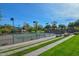 Community tennis courts with lighting, green surface, fencing, and surrounding landscaping at 13145 W Whisper Rock Trl, Peoria, AZ 85383