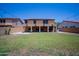 Open backyard with an inviting patio, expansive lawn and a house with solar panels at 13601 W Hearn Rd, Surprise, AZ 85379