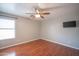 Bedroom with wood-look floors, ceiling fan, mini blinds and a mounted television at 13601 W Hearn Rd, Surprise, AZ 85379