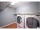 Bright laundry room features a washer and dryer, wood-look tile floors, shelving, and modern design at 13601 W Hearn Rd, Surprise, AZ 85379