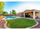 Sprawling backyard features a pool and outdoor kitchen at 14687 W Amelia Ave, Goodyear, AZ 85395