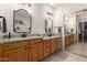Bright bathroom boasts dual sinks, granite countertops, and updated fixtures, with shiplap accent wall and sliding mirror closet at 14687 W Amelia Ave, Goodyear, AZ 85395
