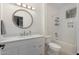 Neat bathroom featuring a round mirror, modern fixtures, and a combined shower and tub, designed for functionality and style at 14687 W Amelia Ave, Goodyear, AZ 85395