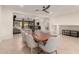 Bright dining room with large wood table and seating for eight beneath a modern ceiling fan and tile floors at 14687 W Amelia Ave, Goodyear, AZ 85395