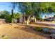 Attractive home featuring desert landscaping with cacti and a mature shade tree in the front yard at 14687 W Amelia Ave, Goodyear, AZ 85395