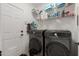 The laundry room has a door and new side-by-side washer and dryer at 14687 W Amelia Ave, Goodyear, AZ 85395