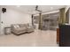 Comfortable living room with tile flooring, sectional sofa, modern ceiling fan, and sliding glass doors at 14687 W Amelia Ave, Goodyear, AZ 85395