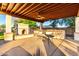 Covered patio offers a built in fireplace and bar seating with an overhead fan for ultimate comfort at 14687 W Amelia Ave, Goodyear, AZ 85395
