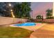Backyard pool features a rock waterfall feature and night lighting at 14687 W Amelia Ave, Goodyear, AZ 85395
