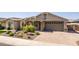 An inviting exterior with desert landscaping, a paved driveway, and a two car garage at 15078 W Mckinley St, Goodyear, AZ 85338