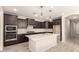 Contemporary kitchen featuring a spacious island, dark cabinetry, and tile backsplash at 15078 W Mckinley St, Goodyear, AZ 85338