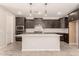 Modern kitchen with dark cabinets, stainless steel appliances, and a center island at 15078 W Mckinley St, Goodyear, AZ 85338