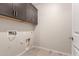 Functional laundry room with upper cabinets, tile floor, and utility connections at 15078 W Mckinley St, Goodyear, AZ 85338