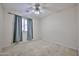 Bright bedroom with neutral walls, carpet, ceiling fan, and window with curtains at 16126 N 159Th Dr, Surprise, AZ 85374