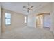 Large bedroom with neutral carpet, ceiling fan, and doorway to an ensuite bathroom at 16126 N 159Th Dr, Surprise, AZ 85374