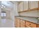 Charming kitchen featuring wood cabinets, granite countertops, and a view of the adjacent room at 16126 N 159Th Dr, Surprise, AZ 85374