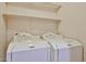 Dedicated laundry room with two modern, white washing machines and shelving at 16126 N 159Th Dr, Surprise, AZ 85374