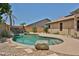 Refreshing backyard pool with lush desert landscaping and a stone waterfall feature for ultimate relaxation at 16126 N 159Th Dr, Surprise, AZ 85374