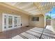 Covered patio with a lattice roof, concrete flooring, and access to the home through glass paneled doors at 1631 E Newport Dr, Tempe, AZ 85282