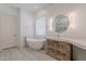 Well-lit bathroom featuring a modern tub, wooden vanity with modern lighting, and neutral colors at 16425 S 34Th St, Phoenix, AZ 85048