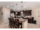 Open concept kitchen featuring dark cabinetry, stainless steel appliances, and a large center island with bar stool seating at 1643 N 144Th Dr, Goodyear, AZ 85395