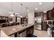 Open kitchen with a large island, stainless steel appliances, and seamless flow into the living area at 1643 N 144Th Dr, Goodyear, AZ 85395