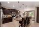Spacious kitchen with dark cabinets, granite countertops, and stainless steel appliances at 1643 N 144Th Dr, Goodyear, AZ 85395