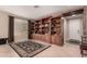 Spacious living area featuring a custom bookcase, neutral walls, and tile flooring at 1643 N 144Th Dr, Goodyear, AZ 85395