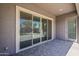 Covered patio area with gray pavers, a sliding glass door to the interior, and an exterior door at 16836 W Vereda Solana Dr, Surprise, AZ 85387