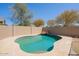 Kidney shaped pool with rock features, surrounded by light-colored pavers and block wall at 16836 W Vereda Solana Dr, Surprise, AZ 85387