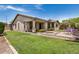 Expansive backyard featuring a covered patio, manicured lawn, attractive fountain, and private outdoor seating area at 1721 W Kingbird Dr, Chandler, AZ 85286