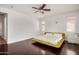 Bright bedroom with ceiling fan, hardwood floors, yellow platform bed, white linens, and plenty of natural light at 1721 W Kingbird Dr, Chandler, AZ 85286