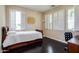 Bright bedroom with dark wood floors, shuttered windows, a bed, and a desk with chair at 1721 W Kingbird Dr, Chandler, AZ 85286