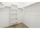Large, open walk-in closet featuring white shelving units and space for storage at 17334 W Eva St, Waddell, AZ 85355