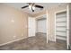 Bedroom with tile flooring, tan walls, ceiling fan, doorway and walk in closet at 18344 W Getty Dr, Goodyear, AZ 85338