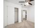 Bedroom with neutral carpet, white walls, ceiling fan, closet and entrance doorway at 18344 W Getty Dr, Goodyear, AZ 85338