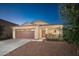 Charming home featuring a brown two-car garage and inviting front porch with stone accents at 18344 W Getty Dr, Goodyear, AZ 85338